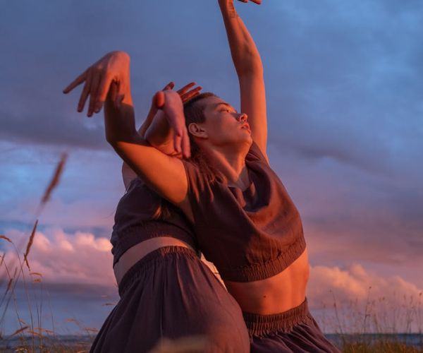 Woman performing a light, fluid cardio movement in a bright, calm space.